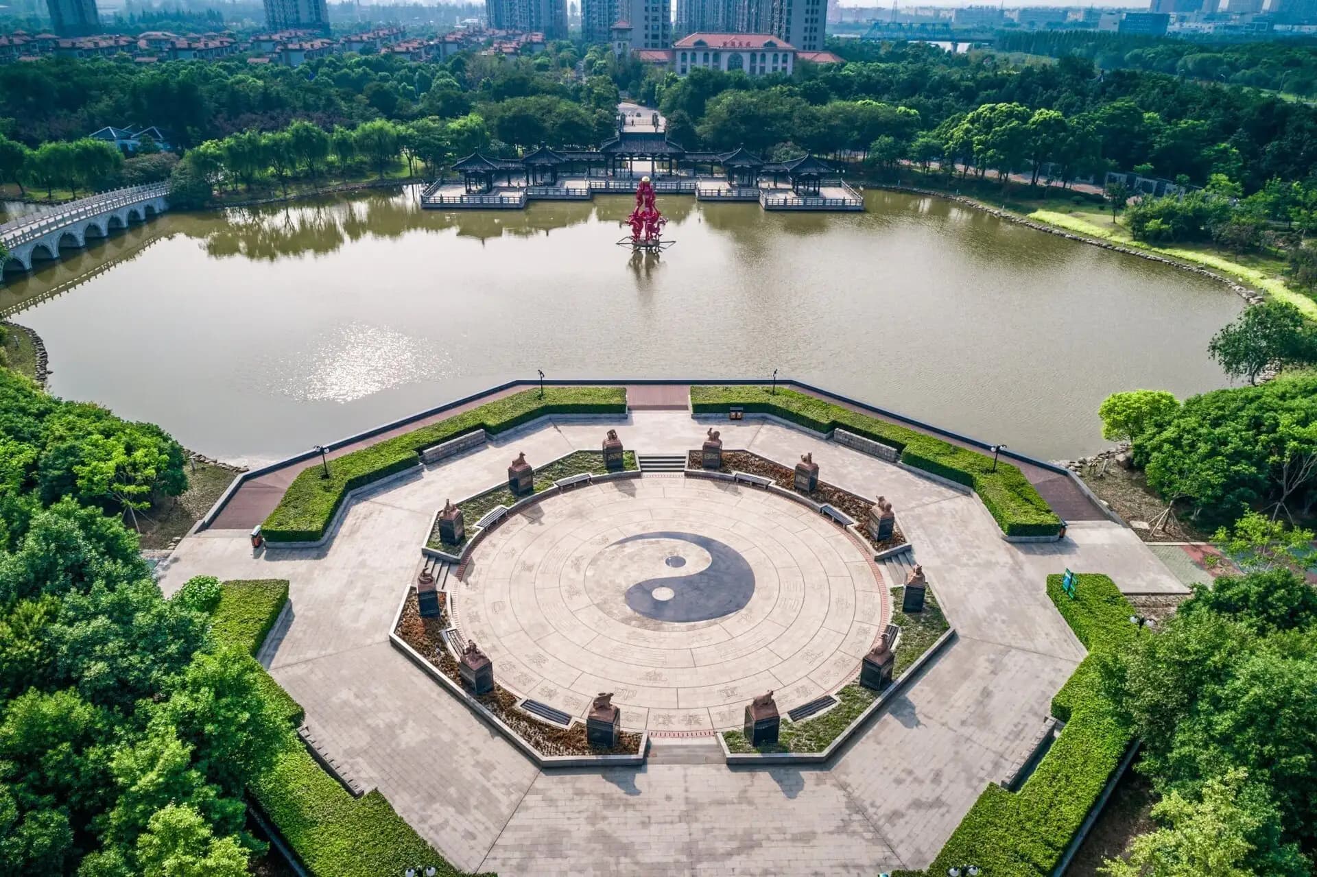An aerial view of a yin-yang plaza surrounded by gardens and water
